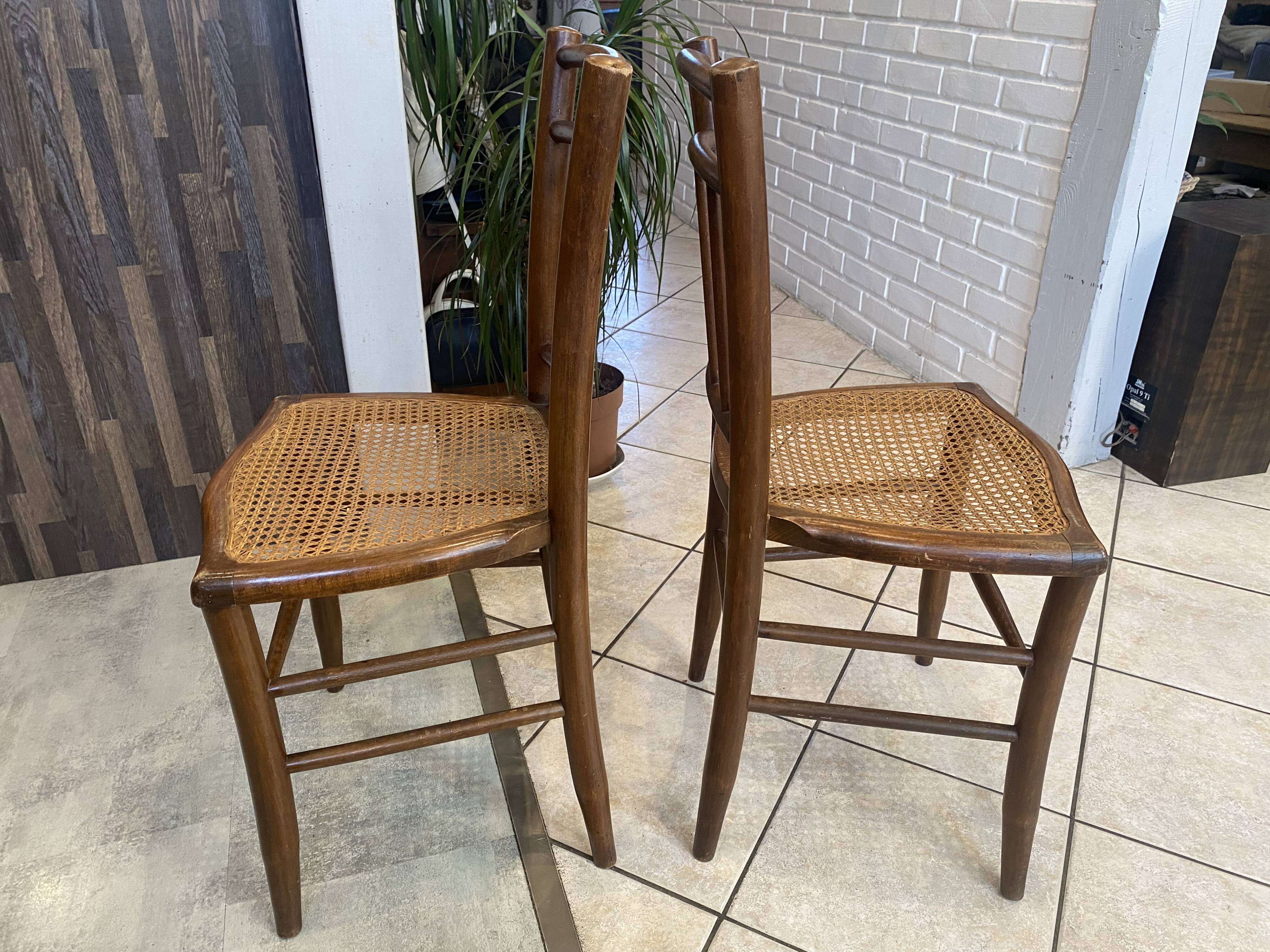 Pair of antique caned and wooden chairs from the 1900s.