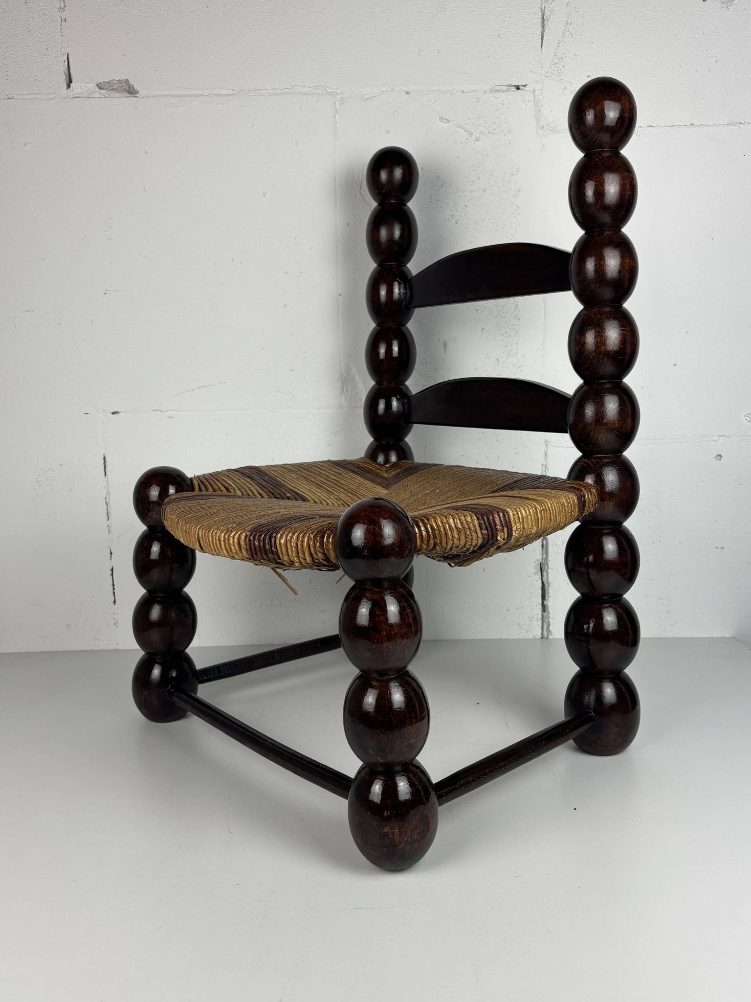Brutalist wood turned bobbin low rush chair n the style of Charles Dudouyt