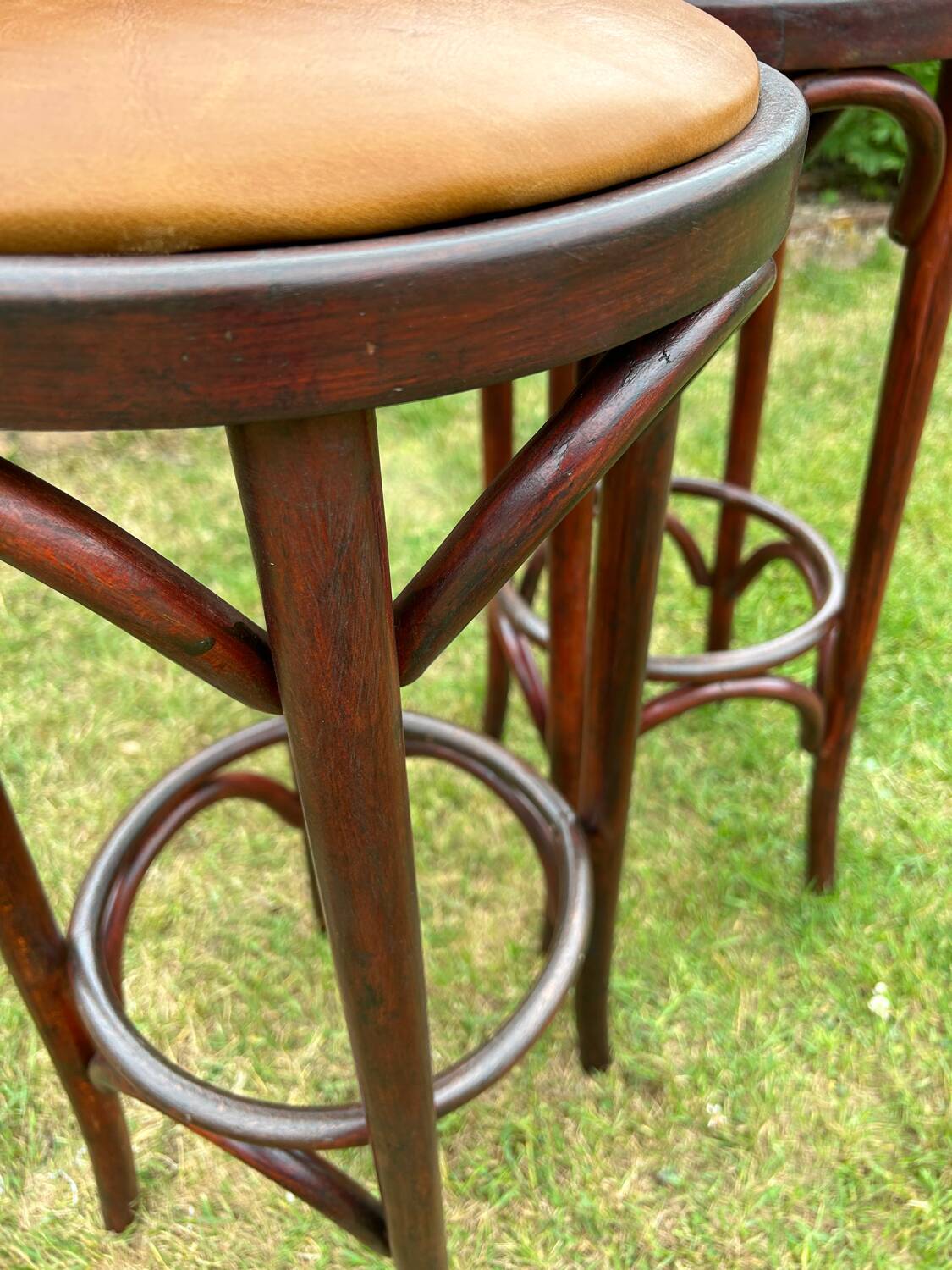 Pair of curved wooden bistro stools with leather seats