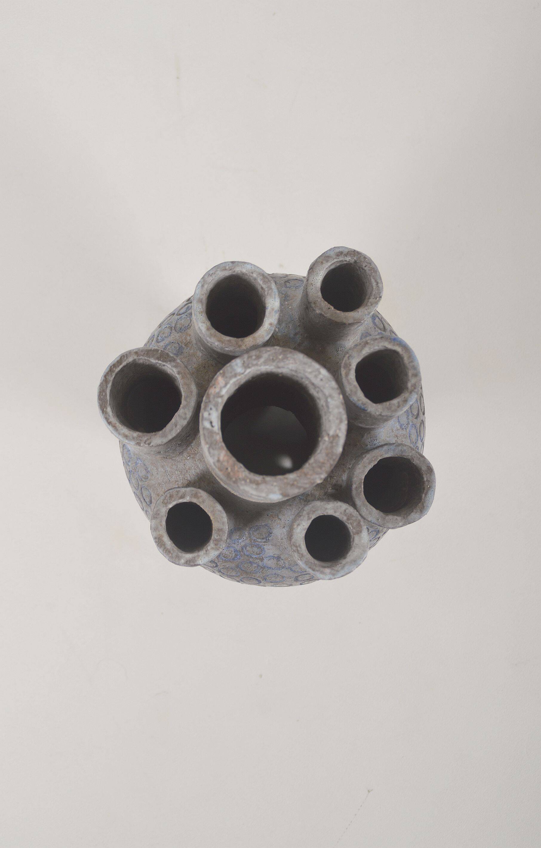 Sculpture en céramique avec des motifs circulaires et une signature.
