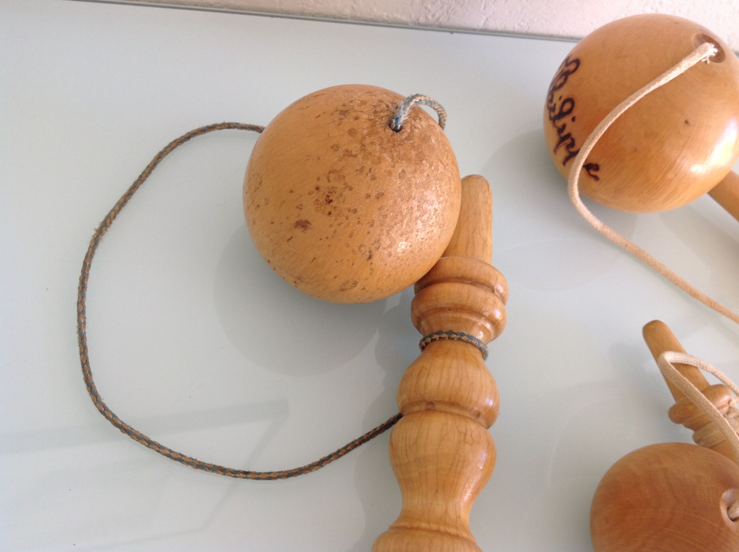 Suite de trois anciens bilboquets en bois clair