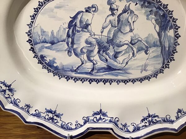 Plat ovale en faïence à décor d’une scène de chasse signée