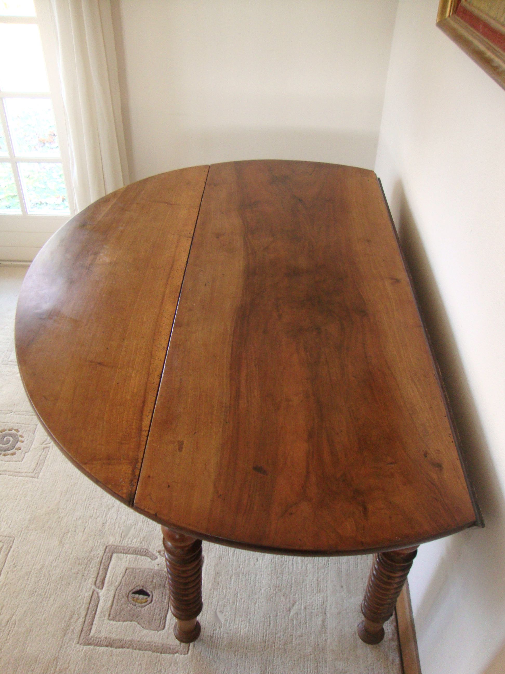 Mid-19th-century walnut round table with shutters, flaps