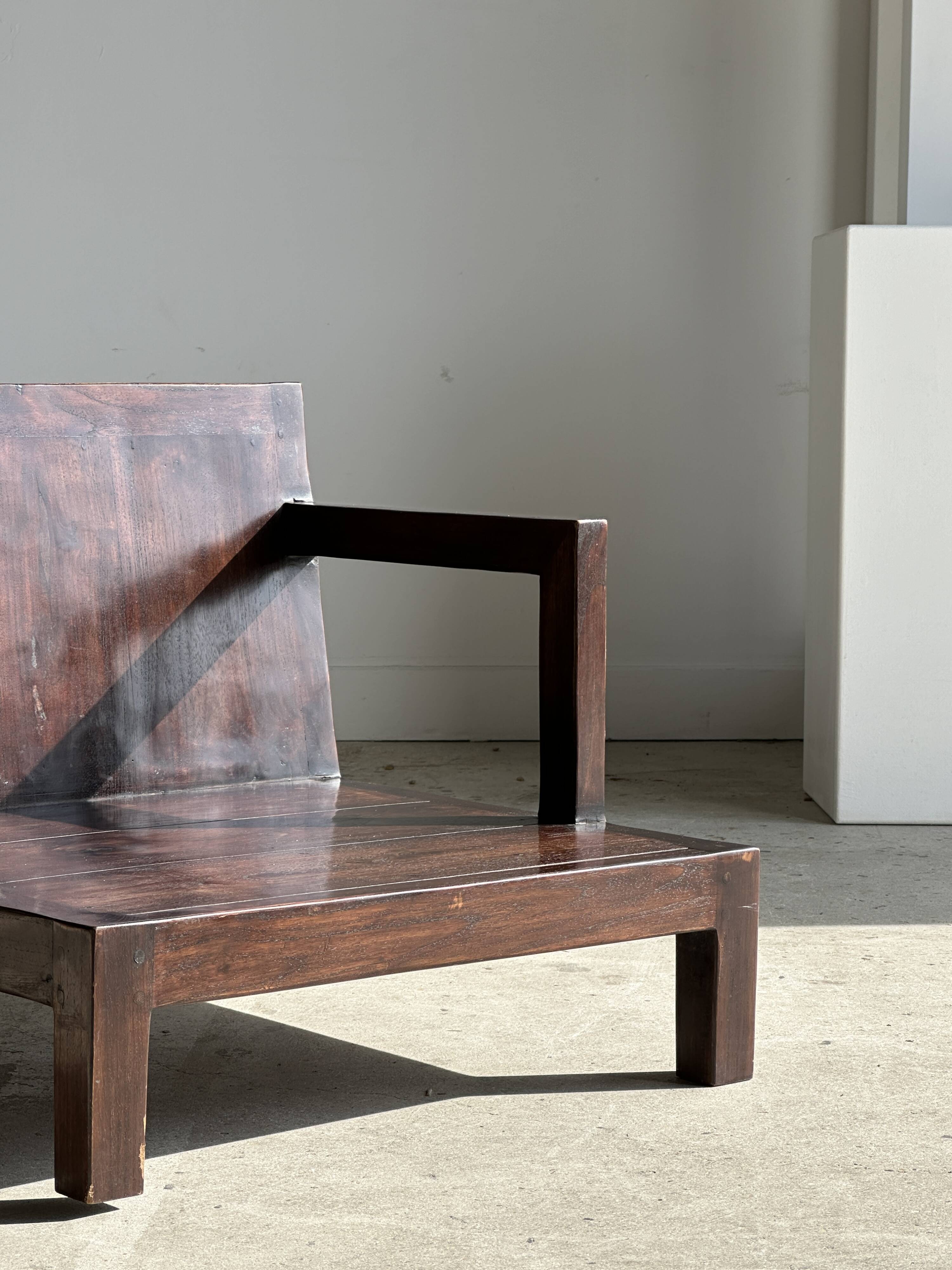 Small low armchair in varnished brown wood