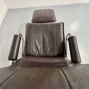 Vintage leather reclining armchair and its 1970s designer ottoman.