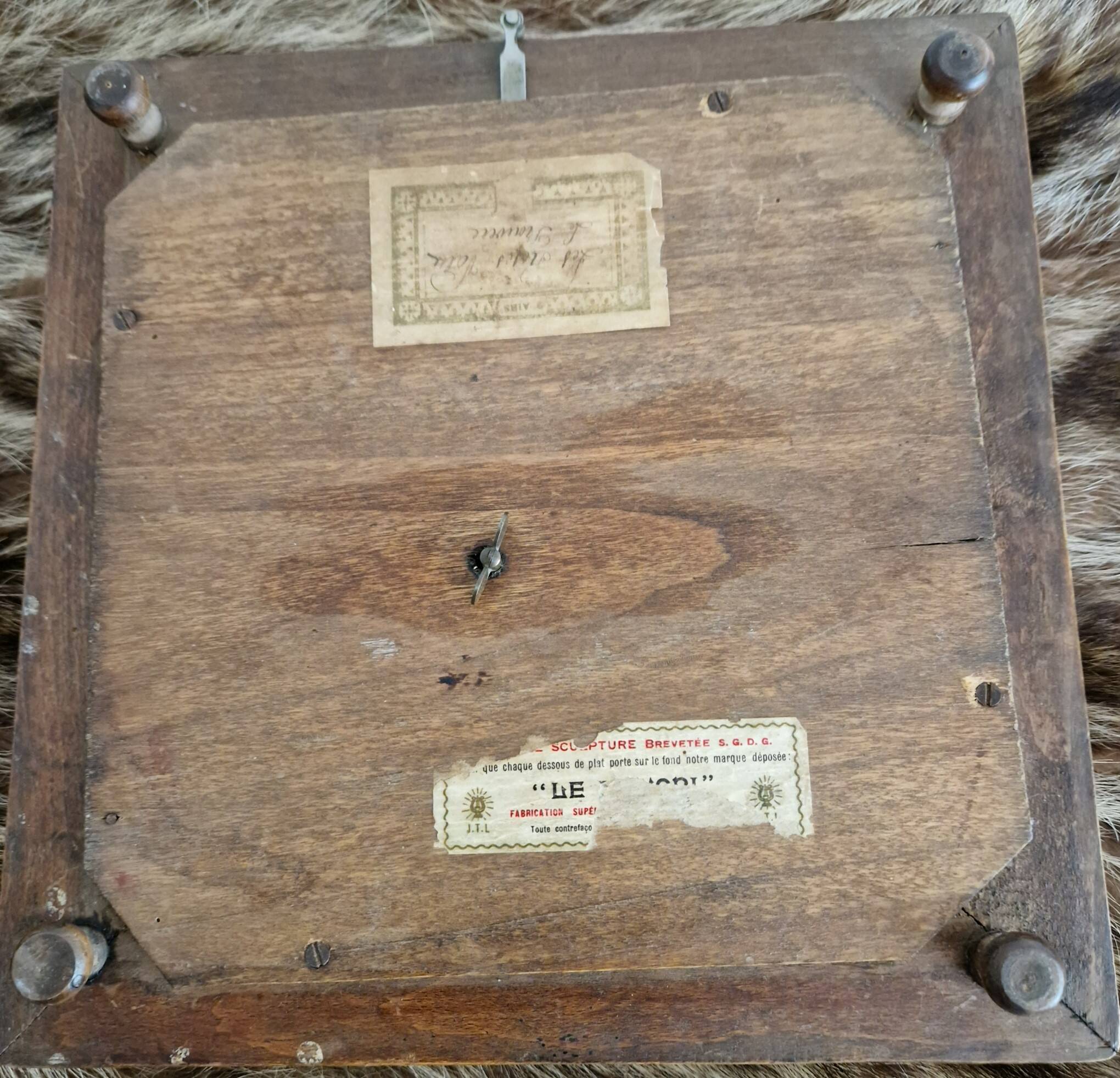 Antique musical trivet made of carved wood and Belle Époque earthenware.