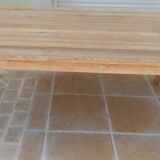 Large natural wood table with rectangular top supported by legs
