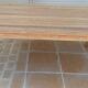 Large natural wood table with rectangular top supported by legs