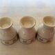 Three egg cups with geometric patterns in beige and brown.