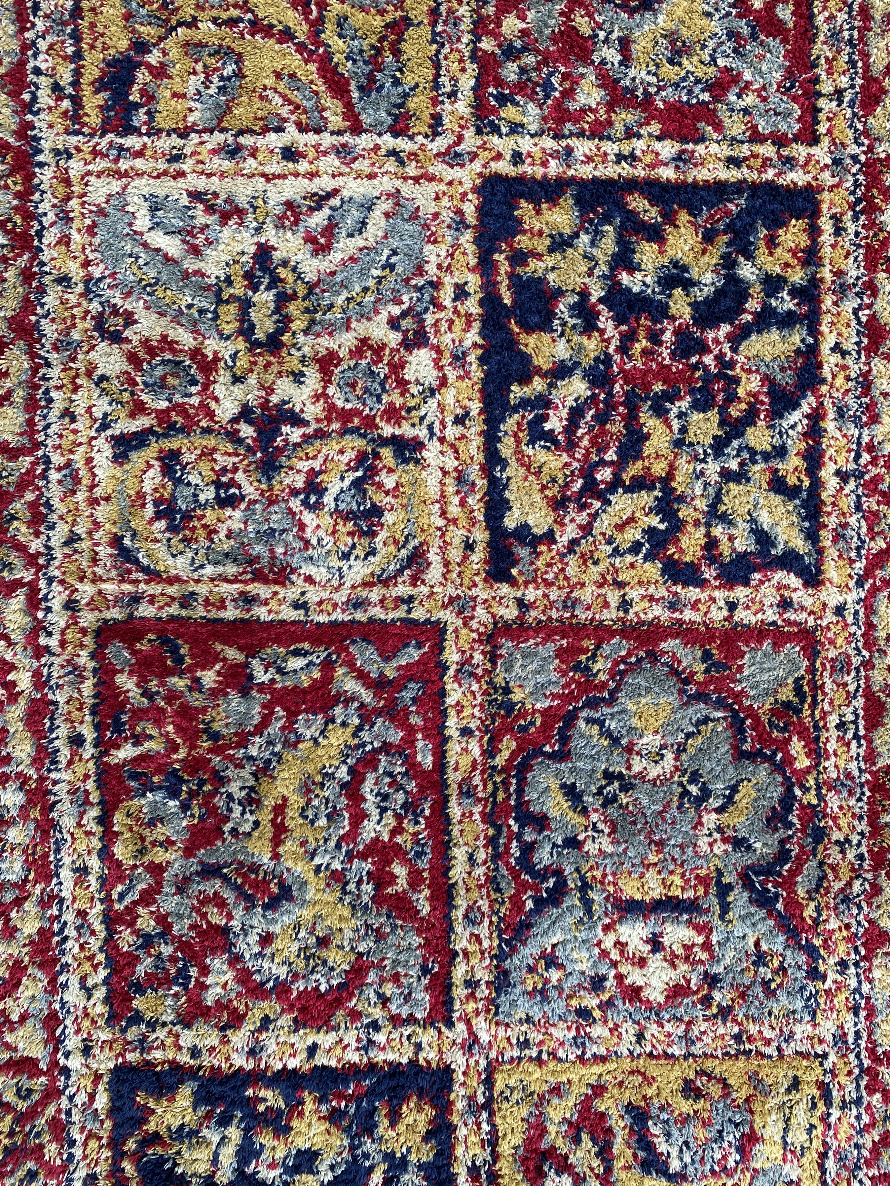 Vintage mechanical Turkish rug with box decoration on a red and navy blue background 139 x 68 cm