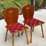 2 curved wood and red fabric chairs