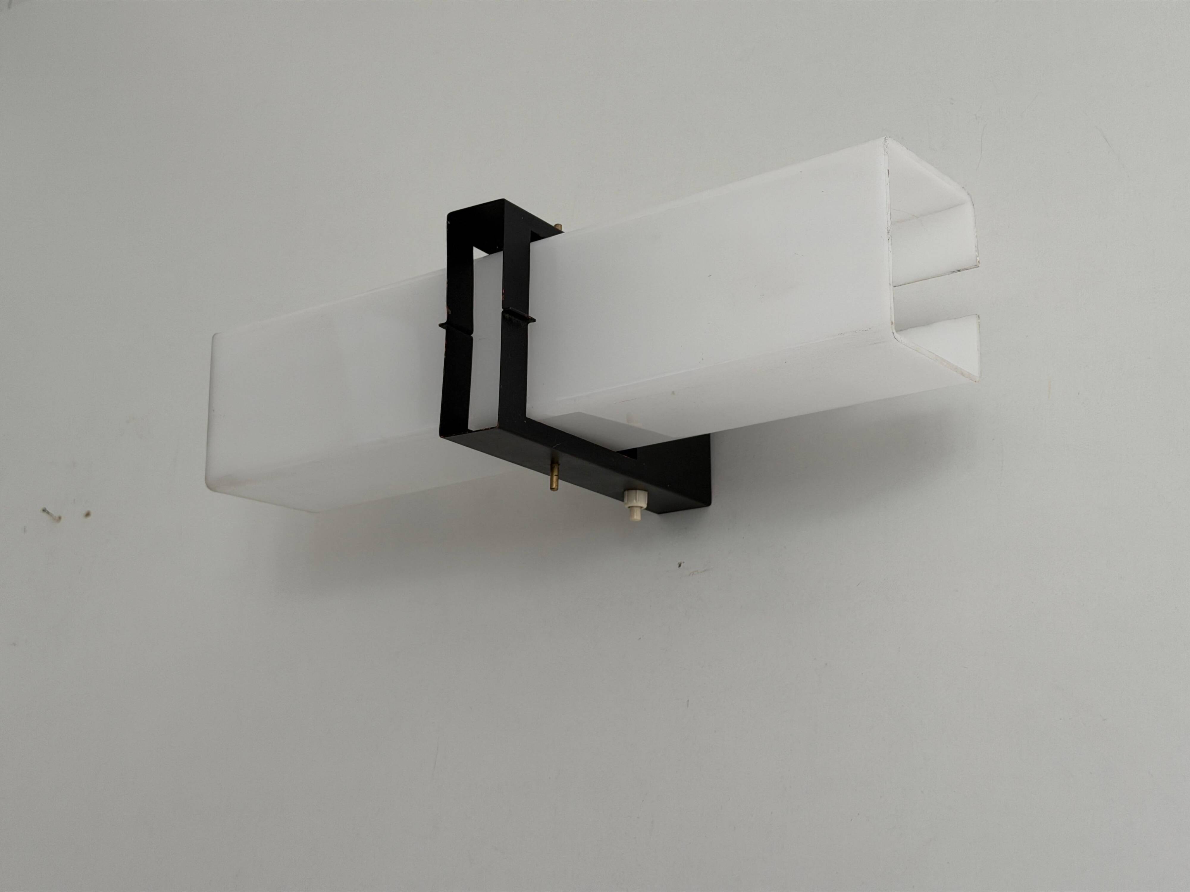 Simple white plexiglass wall light with a black metal frame, 1970s, Germany.