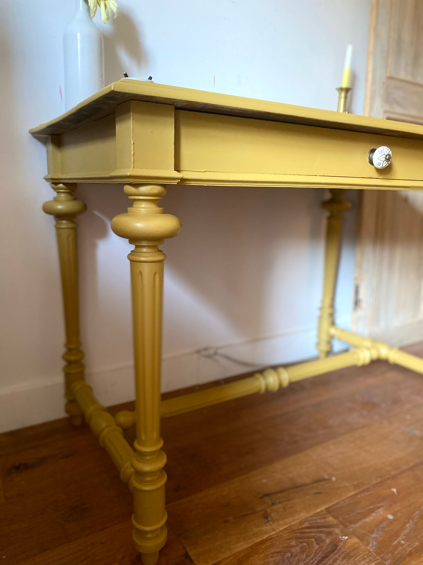 Desk table from the late 19th century, painted mustard, with turned stretcher.