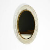 Mid Century Modern round wall mirror with a white expanded metal frame