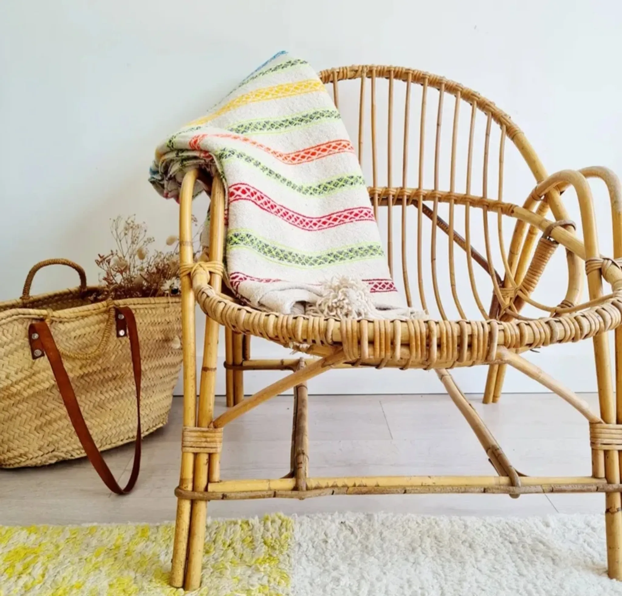 Moroccan plaid made of handwoven wool, decorated with stripes and pom-poms.