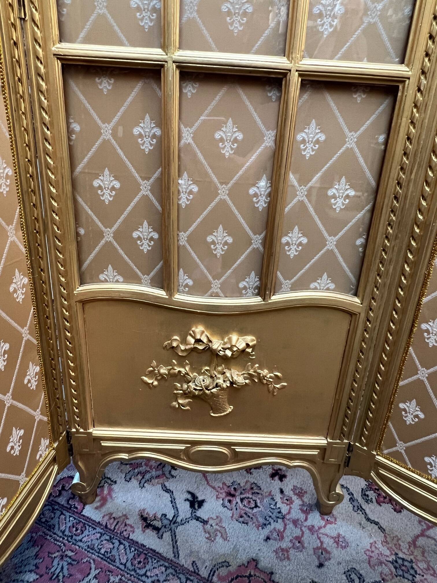 Paravent en bois doré décoré dans le style Louis XVI, orné de têtes de bélier.