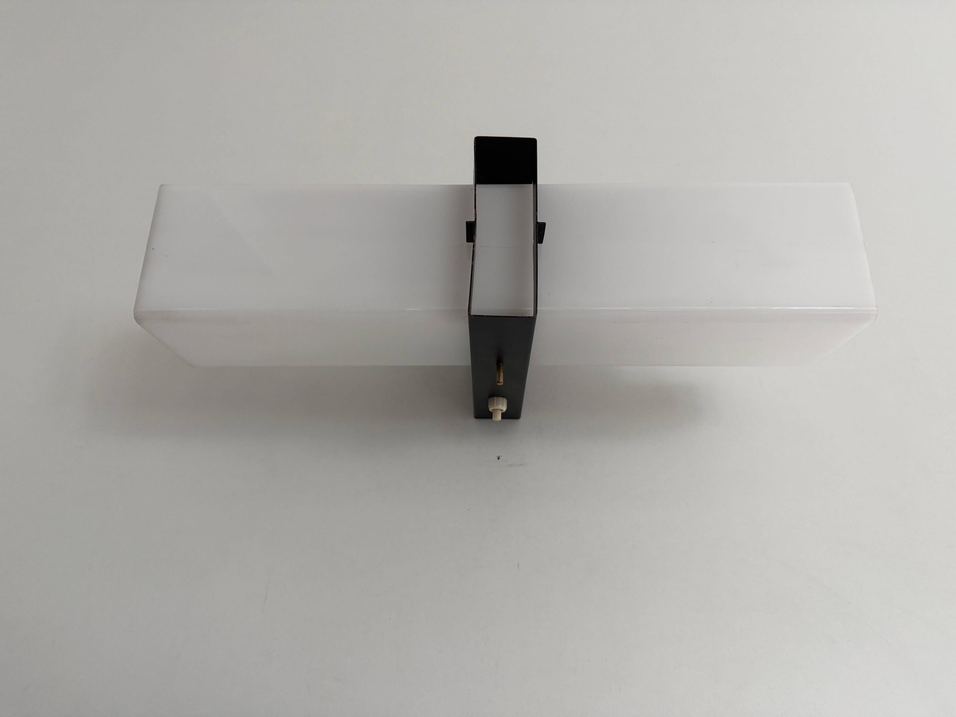 Simple white plexiglass wall light with a black metal frame, 1970s, Germany.