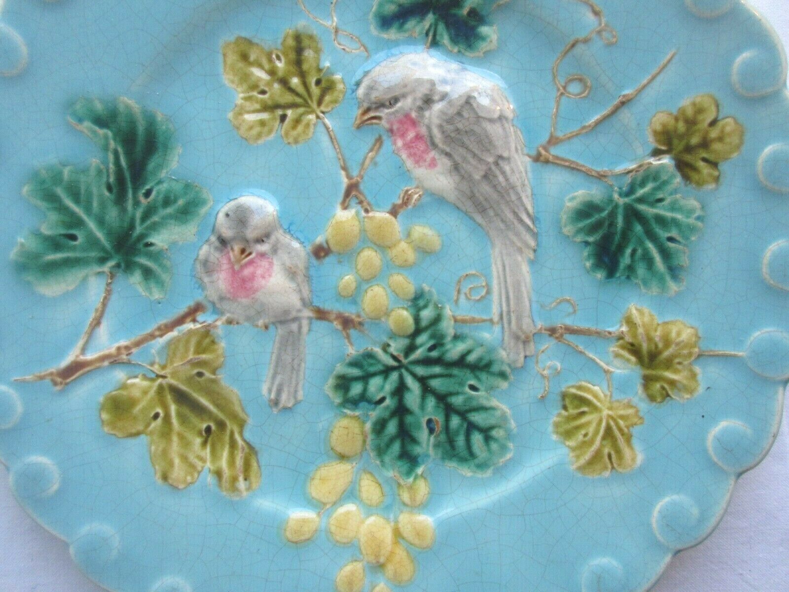 Blue barbotine plate of Sarreguemines: Birds pecking at yellow grapes