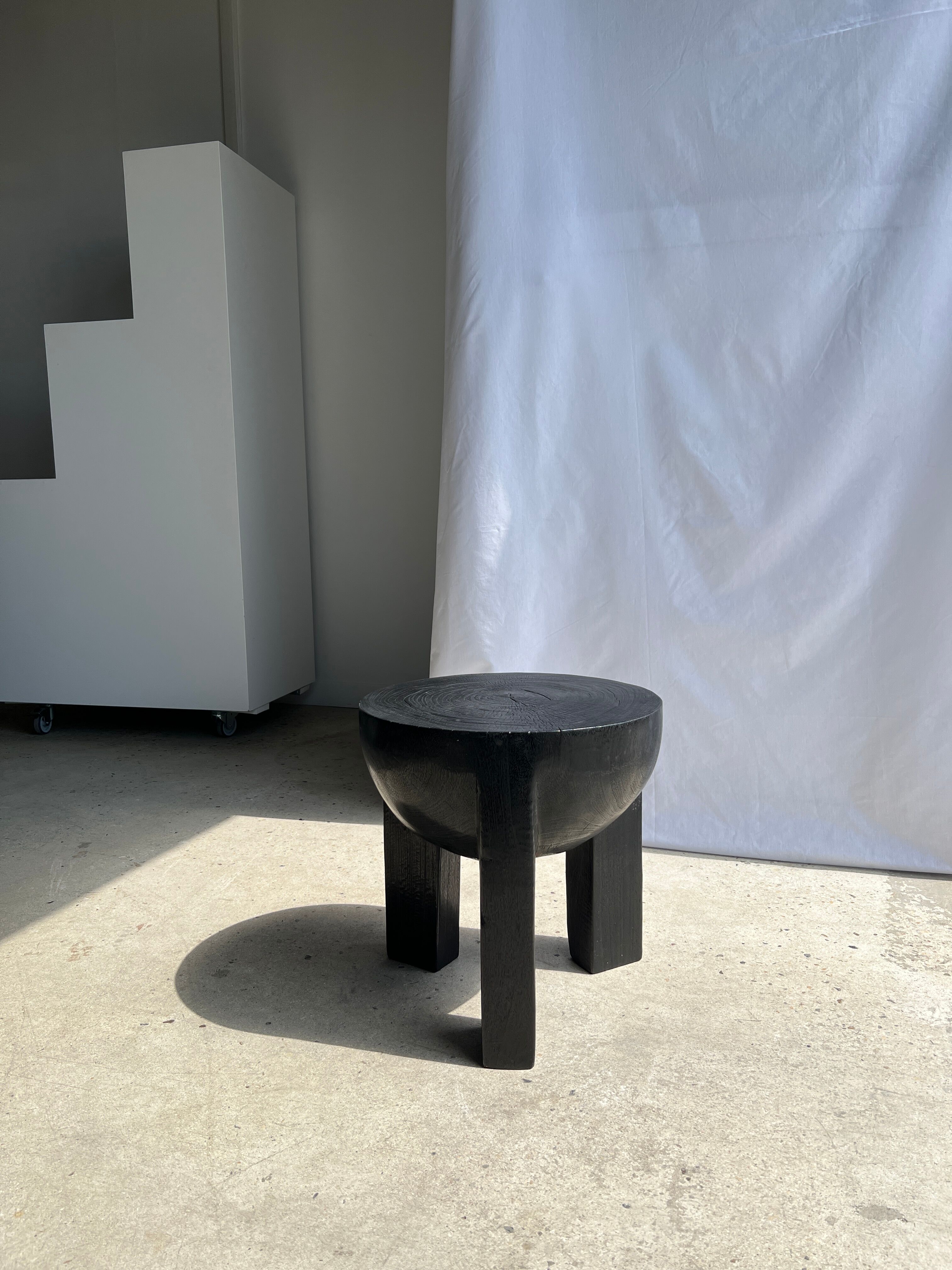 Black mango wood tripod side table with a semi-spherical top, height: 45 cm, diameter: 44 cm.