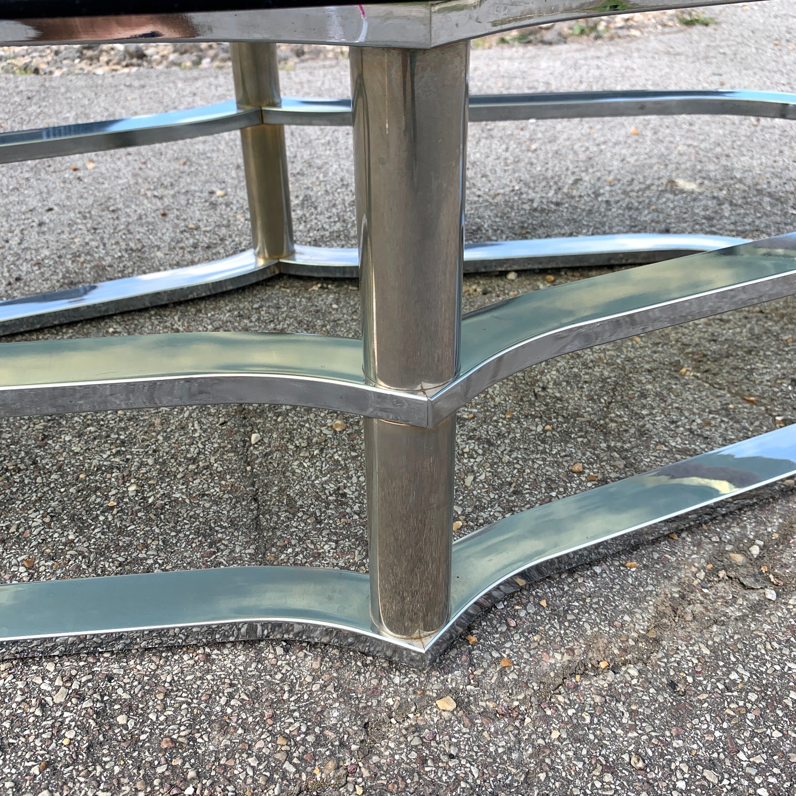 Table basse en acier chromé et verre fumé forme violon