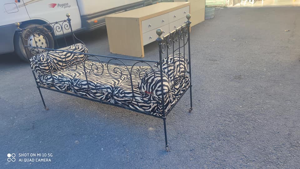 Lit d'enfant transformé en banquette en fer forgé sur roulettes
