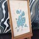 Decorative table with vintage blue flowers in a golden frame.