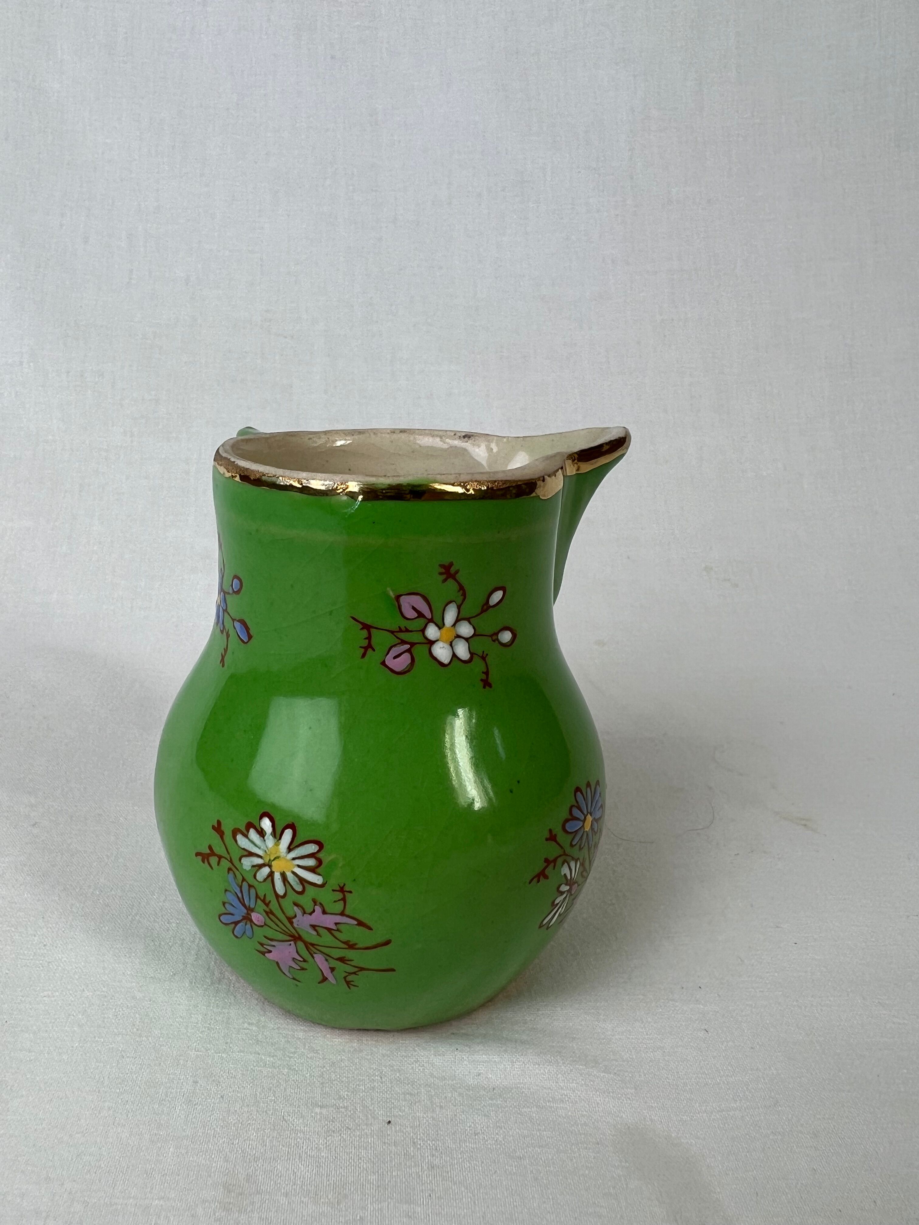 Green milk jug with enamelled flowers