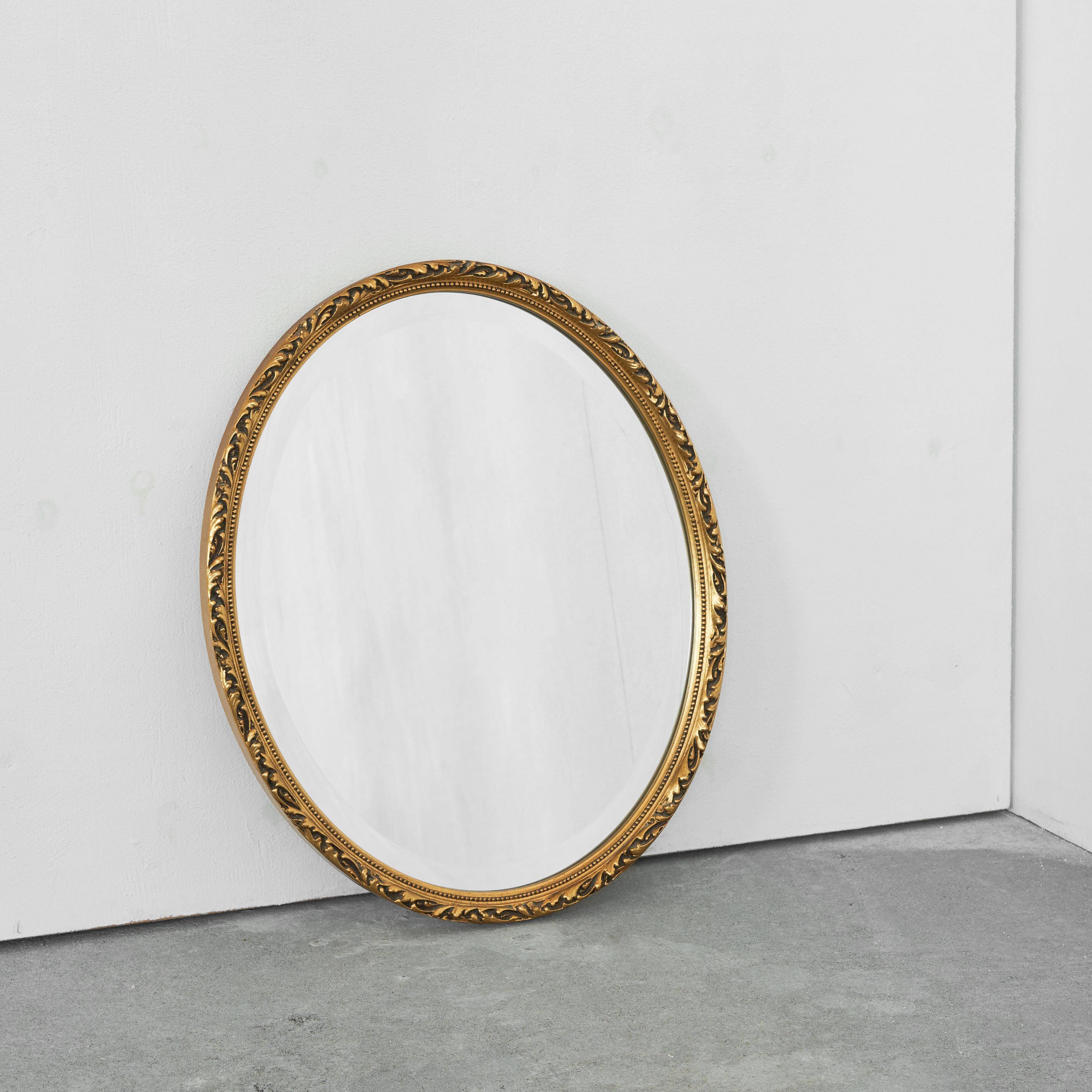 Oval mirror with gilded wood from the 1960s.