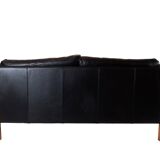 Two seater sofa upholstered with black leather and of danish design