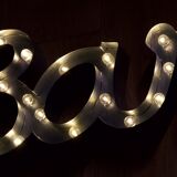 Enseigne lumineuse en lettrage aluminium formant le mot "bar"