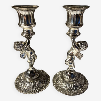 Two silver metal candlesticks decorated with 20th century cherubs