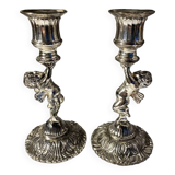 Two silver-plated metal candlesticks decorated with cherubs, 20th century