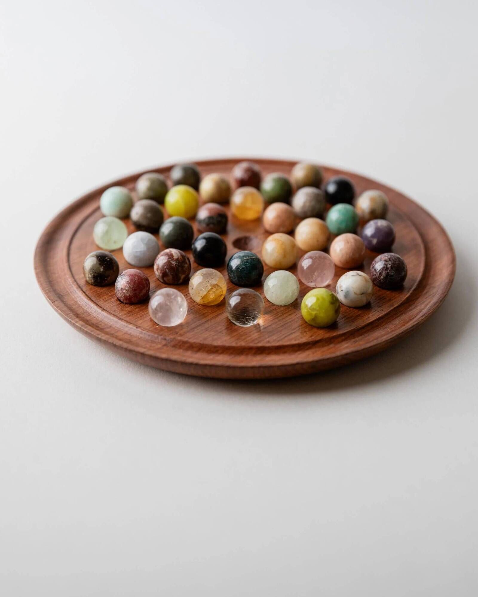 Vintage 1960s solitaire game, wooden board with stone marbles.