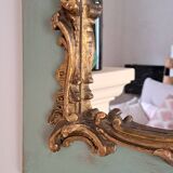 Miroir ancien de style Louis XV en bois et stuc doré.