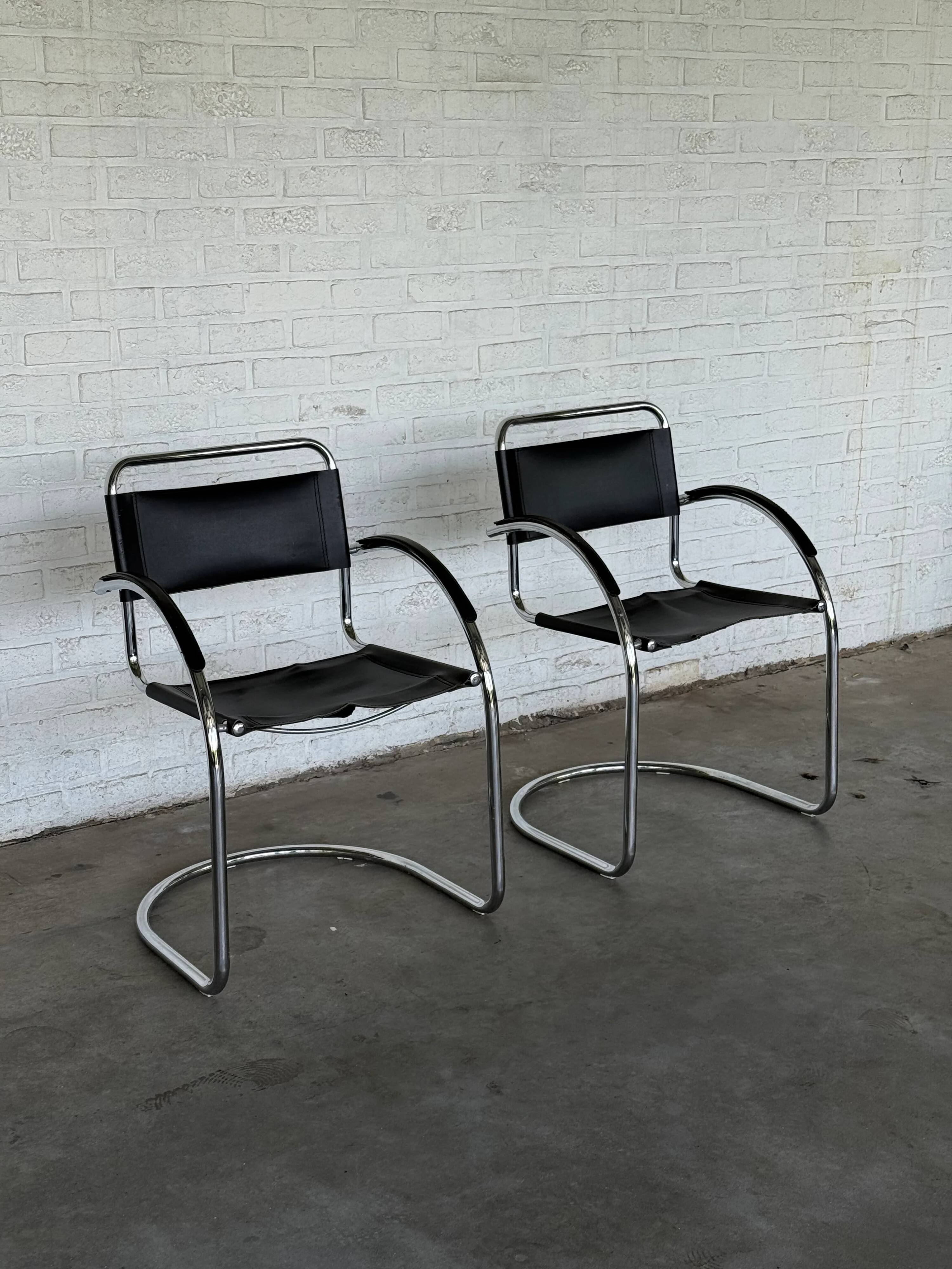 Vintage cantilever chairs in black saddle leather and chrome.