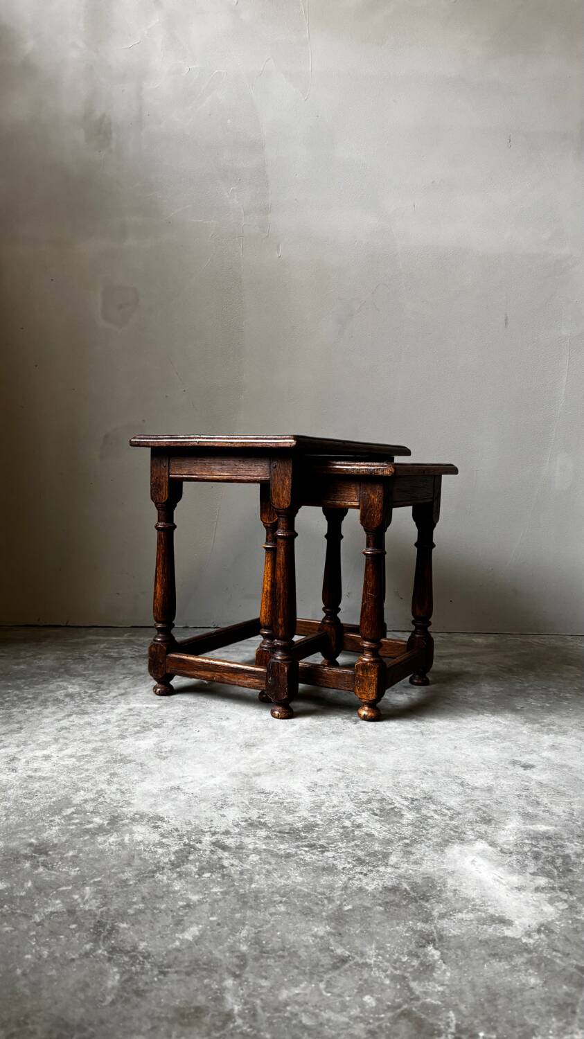 Pair of antique nesting tables made of turned wood.