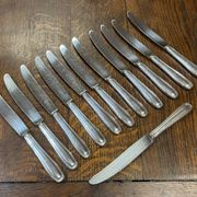 Suite de 12 grands couteaux en métal argenté