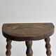 Three-legged demi-lune stool made of turned wood