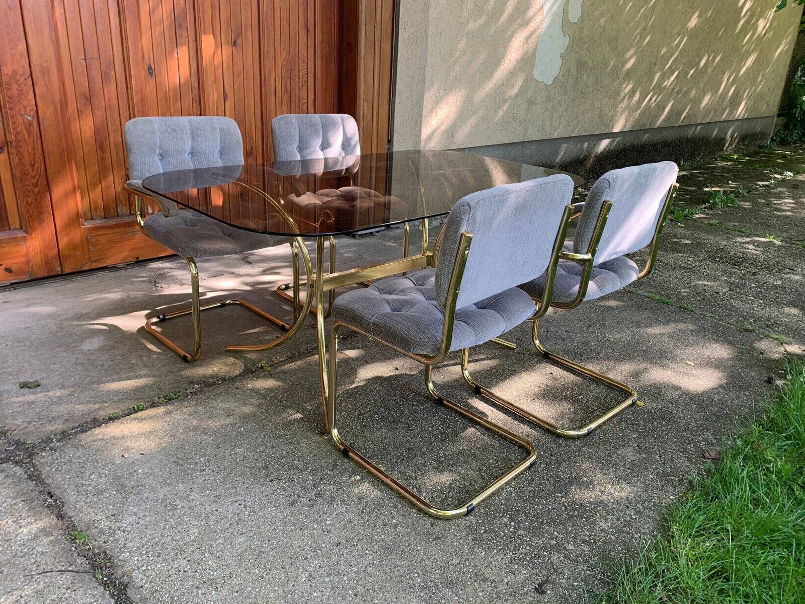 1970s table set with 4 chairs in gold brass and grey fabric, smoked glass top.