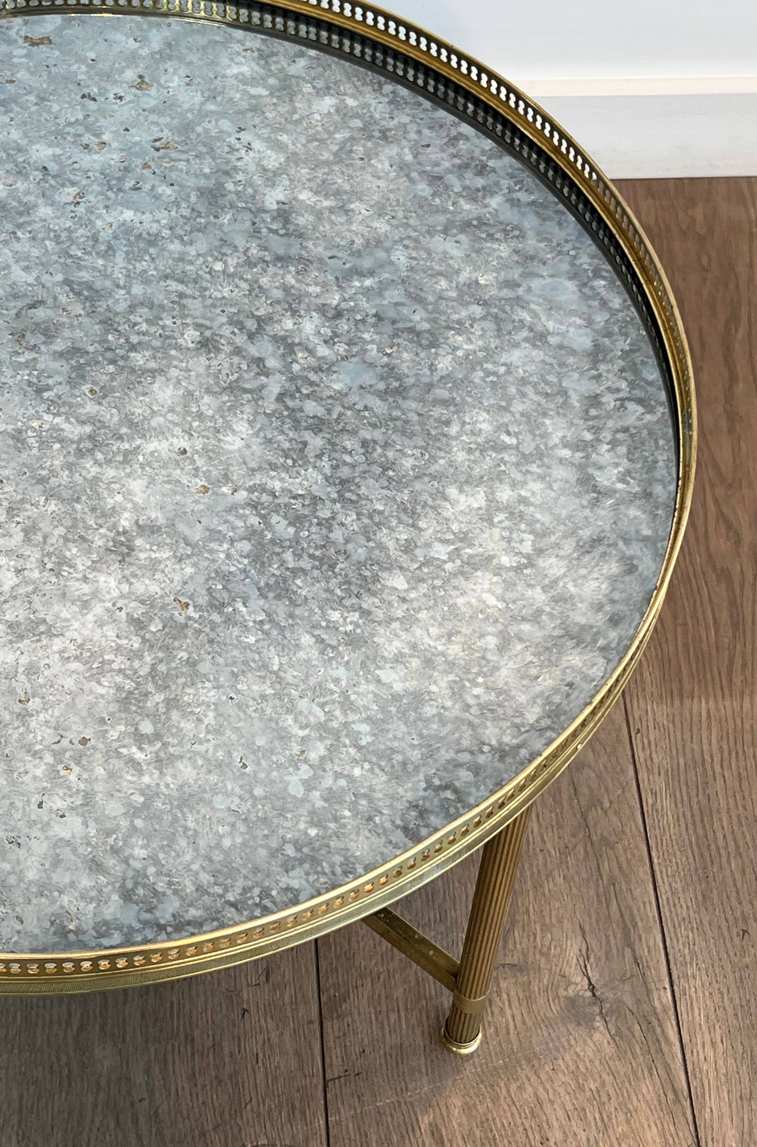 Brass coffee table with a vintage mirror top from the Baguès house.