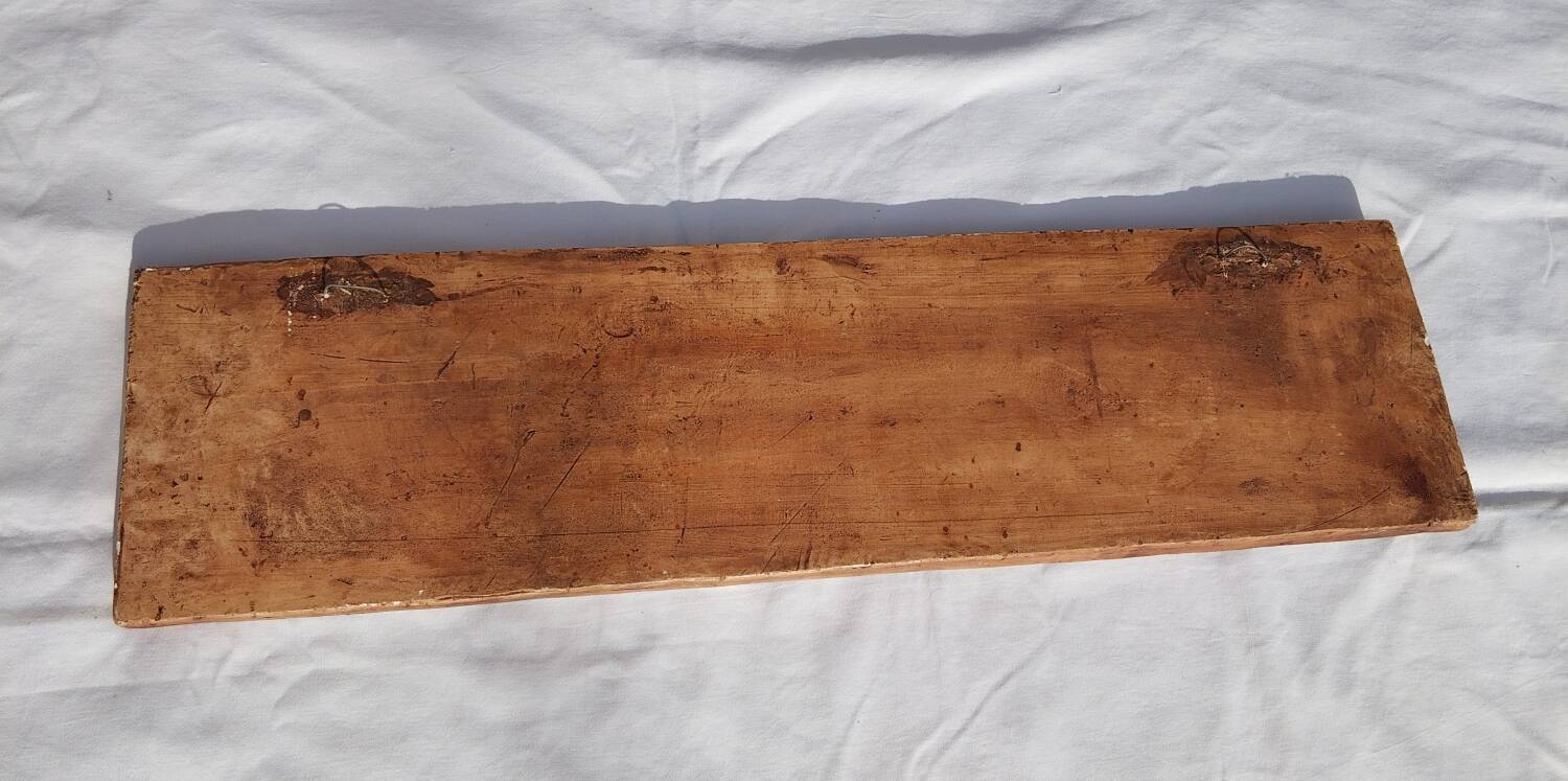 Bas-relief plaster scene of horses and a cart.