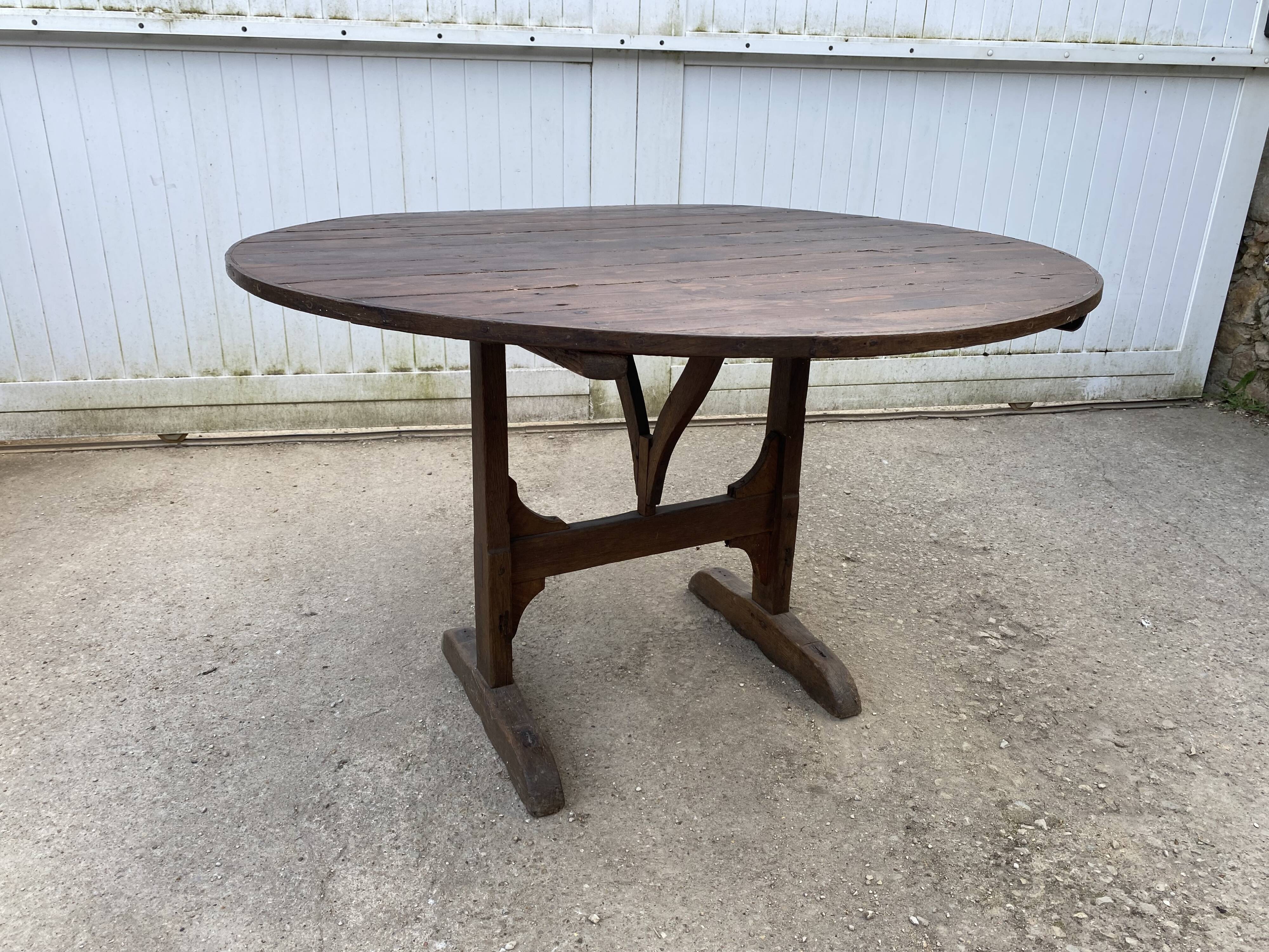 Old folding round winemaker's table with a tilting top.