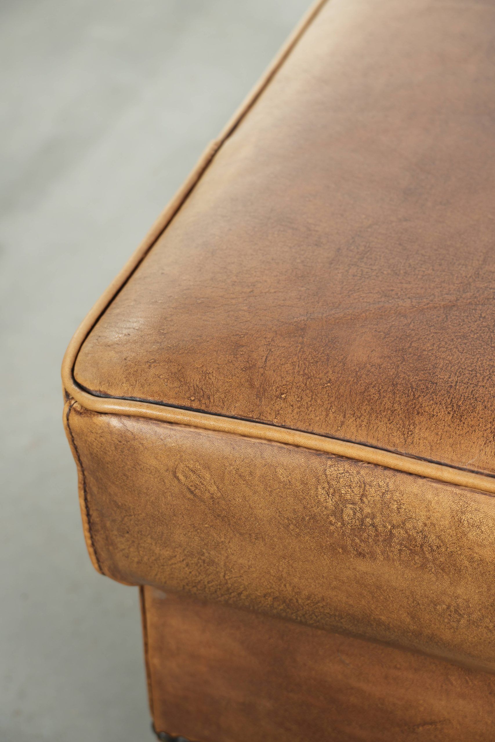 Cowhide ottoman with a beautiful patina finished with decorative nails