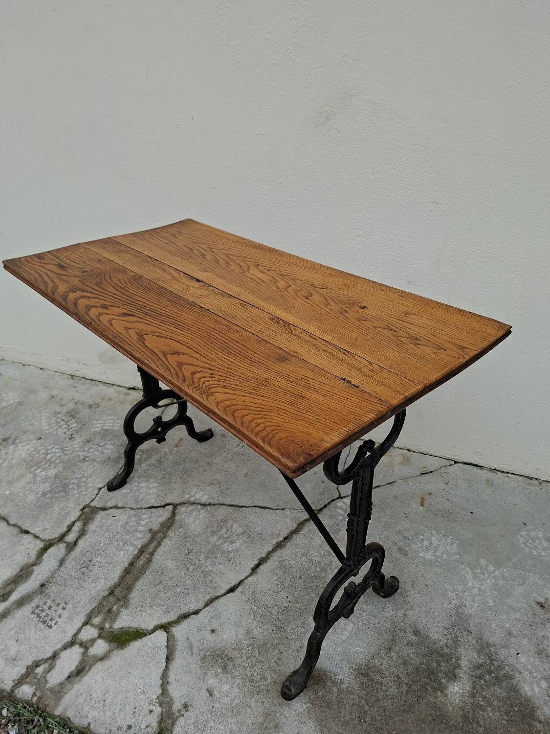 Solid oak bistro table with a cast iron base, signed.