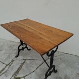 Solid oak bistro table with a cast iron base, signed.