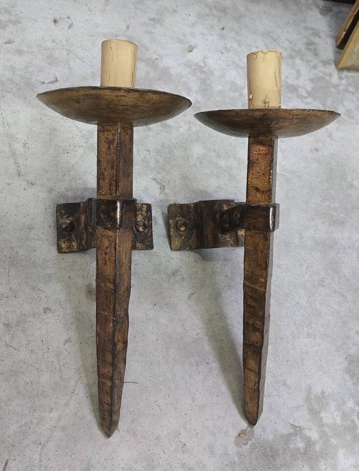 Pair of brutalist wall sconces in hammered and patinated iron, work from the years.