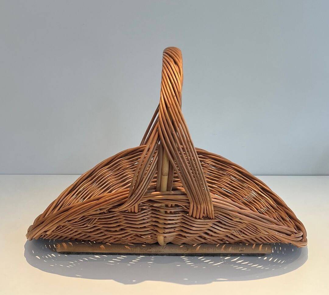 Woven Rattan Log Holder in a Semi-Round Shape with a Central Arched Handle.