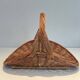 Woven Rattan Log Holder in a Semi-Round Shape with a Central Arched Handle.