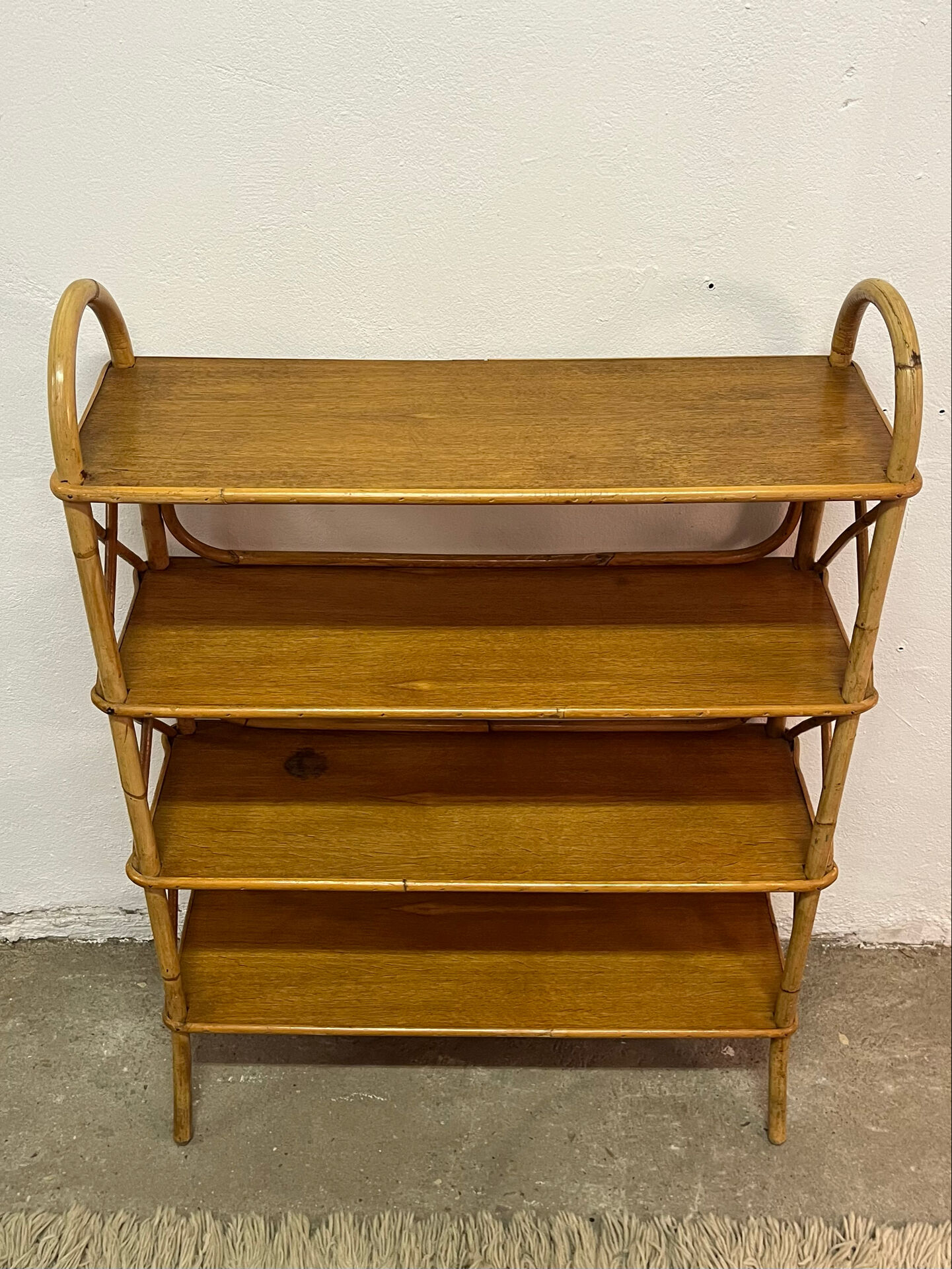 Vintage shelf on legs made of rattan and wood.