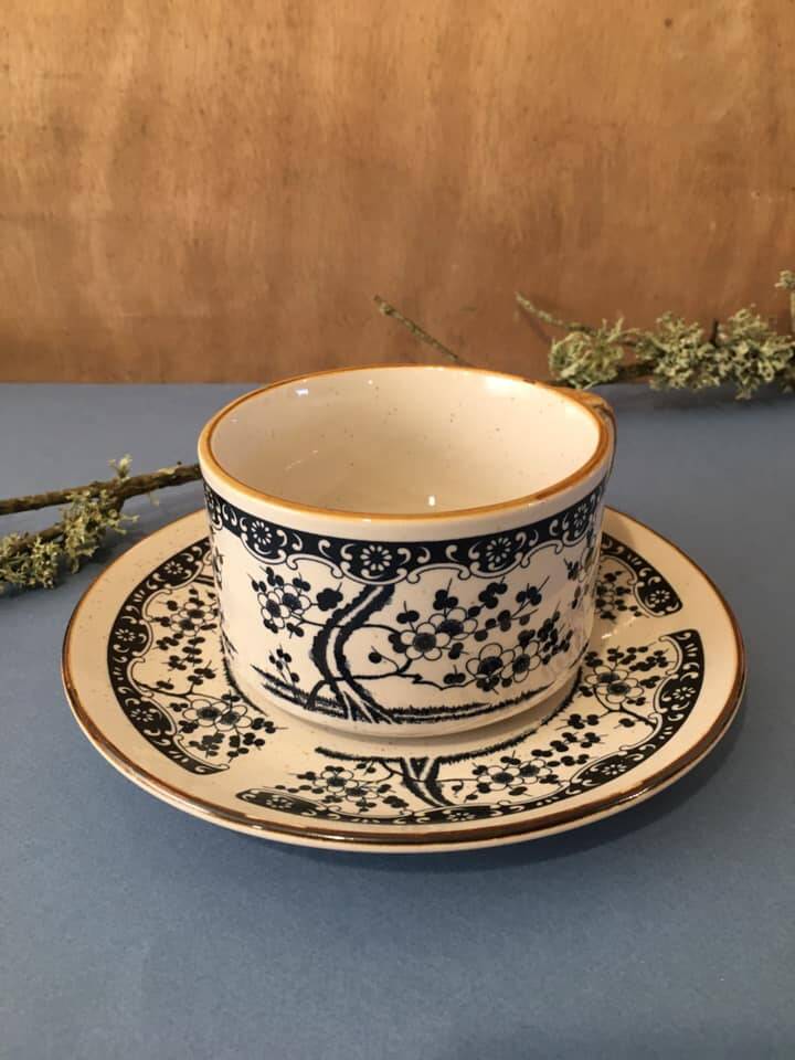 Large stoneware cup and saucer with delicate floral patterns